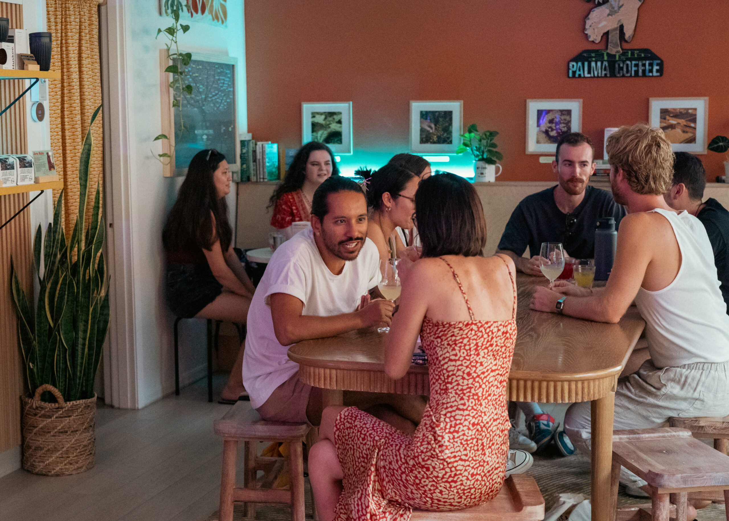 Inside Palma Coffee in Sarasota, with guests gathered at wooden tables